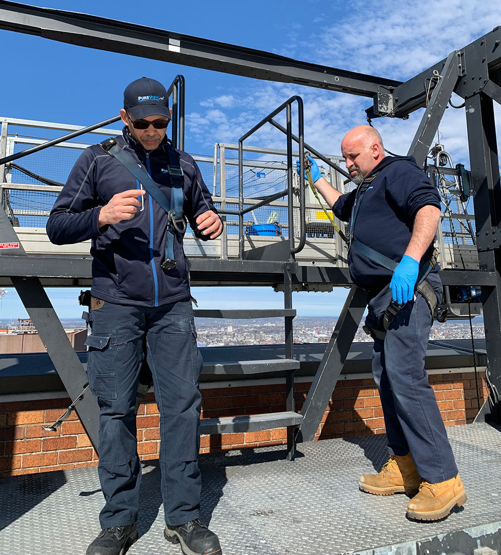 Two workers standing on a rooftop