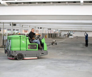 A worker driving a floor cleaner