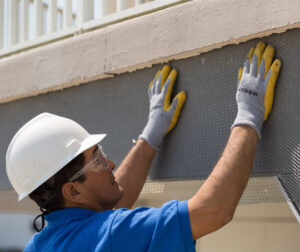A worker inspecting a building's façade
