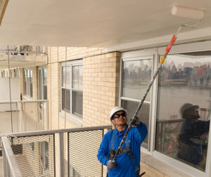 A worker painting a ceiling
