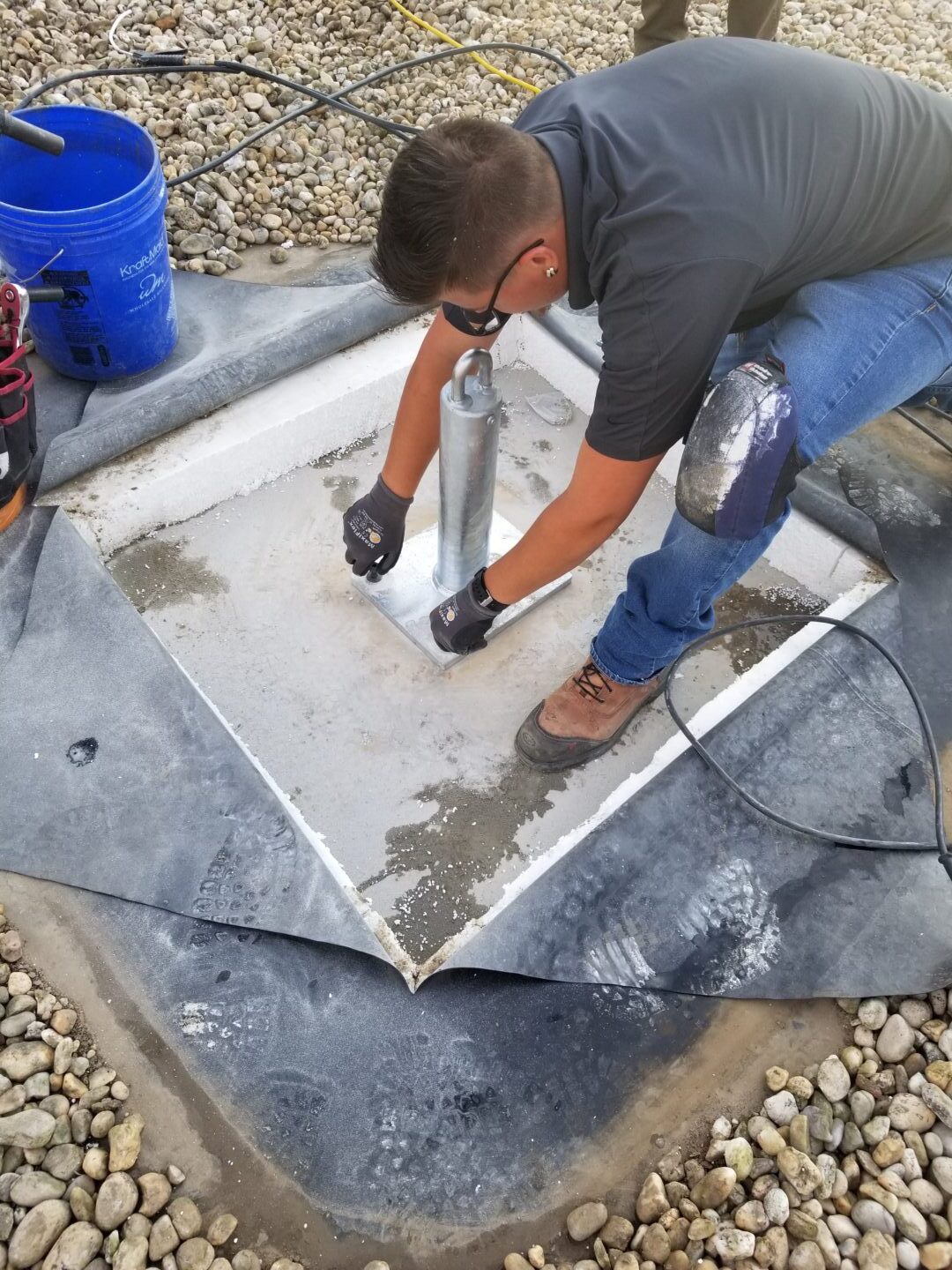 Fall Protection Solutions_Bullet Panel Worker installing a roof anchor.