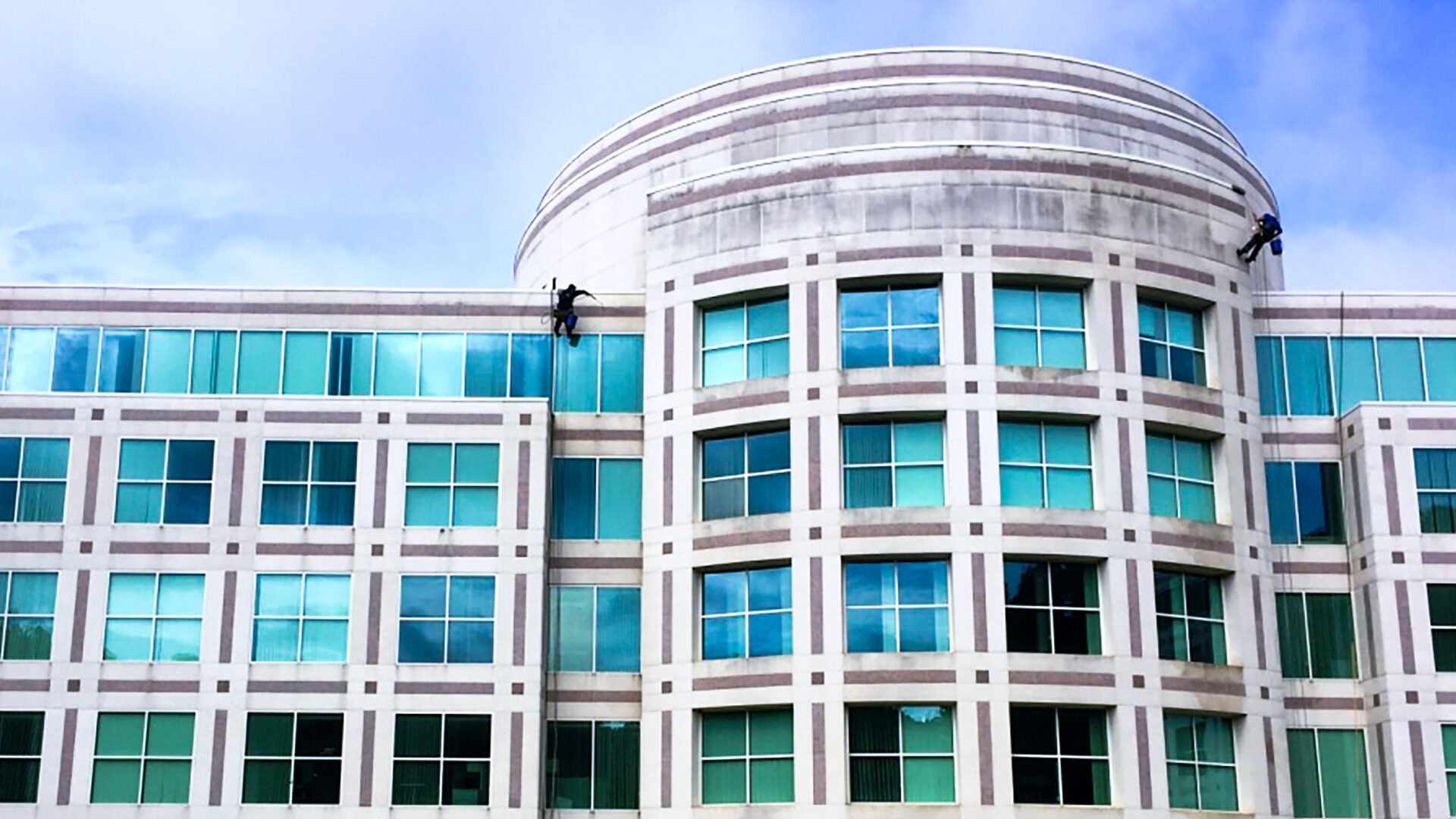 Pressure Washing_Hero Image Workers pressure washing the side of a building