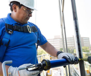 Worker caulking a window.